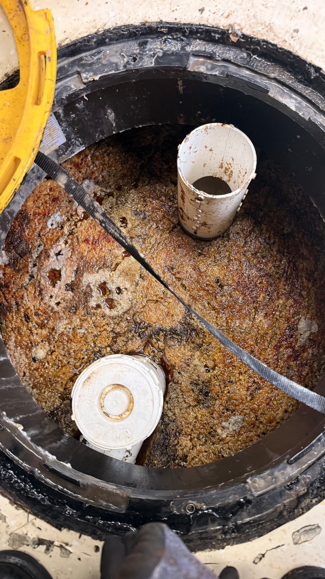 Grease trap filled with accumulated grease and solids before cleaning